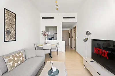 a living room with a couch and a tv at VayK - Comfortable 1BR in JVC in Dubai