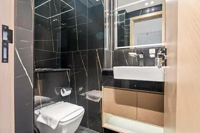 a bathroom with a toilet and a sink and a mirror at VayK - Comfortable 1BR in JVC in Dubai