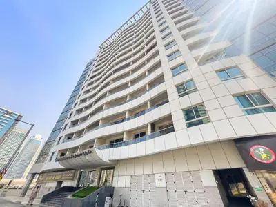 a tall building with the sun shining on it at VayK - Modern 1BR Near Metro in Dubai Marina in Dubai