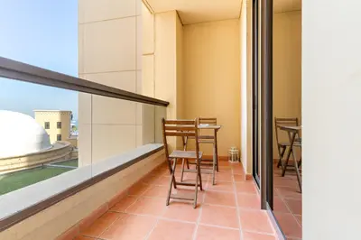 a balcony with chairs and a table on it at VayK - Light-Filled and Spacious 1BR in JBR in Dubai