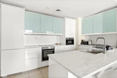 a kitchen with white cabinets and a white counter top at VayK - Light-Filled and Spacious 1BR in JBR in Dubai