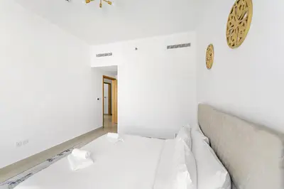 a bedroom with a bed and a clock on the wall at VayK - Generous 2BR Offering Burj Khalifa Views in Dubai