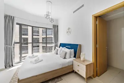 a bedroom with a large bed and a large window at VayK - Generous 2BR Offering Burj Khalifa Views in Dubai
