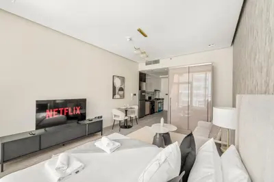 a living room with a couch and a tv at VayK - Chic Studio in Silicon Oasis with Pool View in Dubai