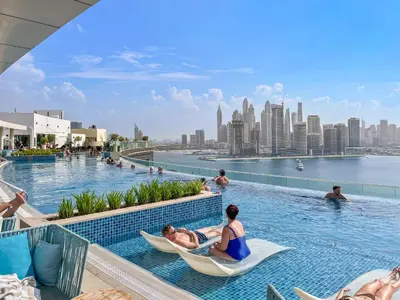 a group of people sitting in hammocks in a pool at a hotel at VayK - Contemporary Studio with Beach Access on Palm Jumeirah in Dubai