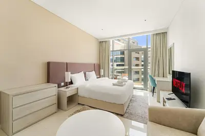 a hotel room with a bed and a tv at VayK - Contemporary Studio with Beach Access on Palm Jumeirah in Dubai