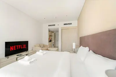 a hotel room with a bed and a tv at VayK - Contemporary Studio with Beach Access on Palm Jumeirah in Dubai