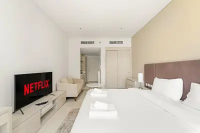 a hotel room with a bed and a tv at VayK - Contemporary Studio with Beach Access on Palm Jumeirah in Dubai