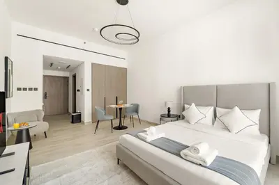 a bedroom with a large bed and a living room at VayK - Refined Studio in Dubai Hills with Pool View in Dubai