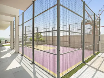 a tennis court in a cage on a building at VayK - Refined Studio in Dubai Hills with Pool View in Dubai