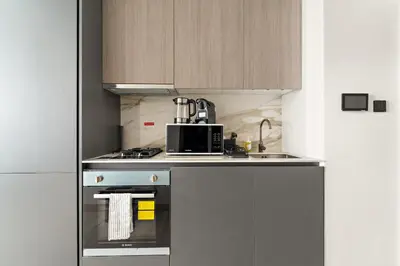 a kitchen with a stove and a microwave at VayK - Refined Studio in Dubai Hills with Pool View in Dubai
