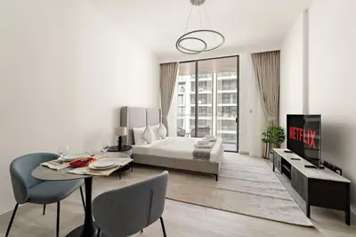 a living room with a bed and a table and chairs at VayK - Refined Studio in Dubai Hills with Pool View in Dubai