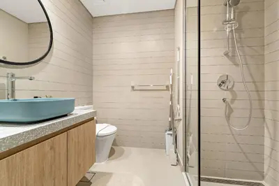 a bathroom with a blue sink and a shower at VayK - Sunlit Studio with Canal Views in Business Bay in Dubai