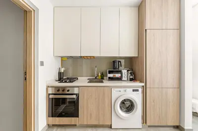 a kitchen with a washing machine and a washer at VayK - Sunlit Studio with Canal Views in Business Bay in Dubai