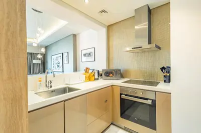 a kitchen with a sink and a stove at Superhost - 1BR , Pool & Gym , DAMAC Towers Paramount in Dubai