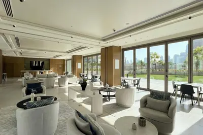 a lobby with white chairs and tables and windows at Signature Luxury Apartments Downtown Dubai in Dubai