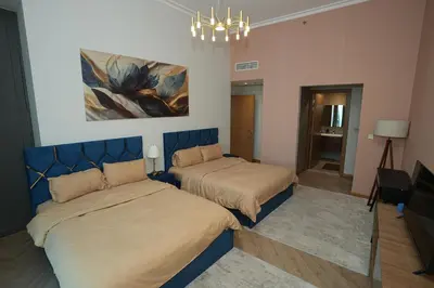 a bedroom with two beds and a painting on the wall at Prime Downtown Luxury Stays by Burj Khalifa in Dubai
