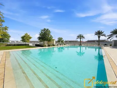 a large swimming pool with blue water at Contemporary 3-Bedroom Villa by Deleguest in Dubai