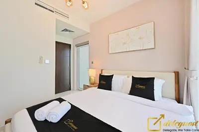 a bedroom with a white bed with black and white pillows at Contemporary 3-Bedroom Villa by Deleguest in Dubai