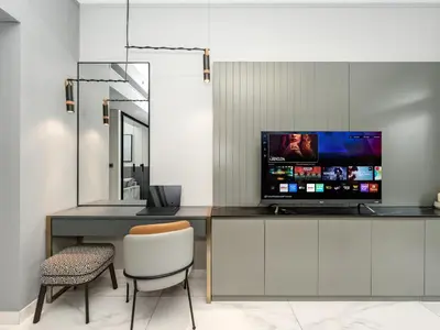 a room with a desk with a television and a chair at Cozy Studio with Balcony I Near Dubai Mall & Downtown in Dubai