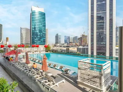 a swimming pool on top of a building with a city at Cozy Studio with Balcony I Near Dubai Mall & Downtown in Dubai