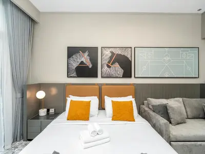 a bedroom with a large bed and a couch at Cozy Studio with Balcony I Near Dubai Mall & Downtown in Dubai