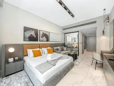 a bedroom with a large bed and a couch at Spacious Studio with Balcony I Near Dubai Mall & Downtown in Dubai