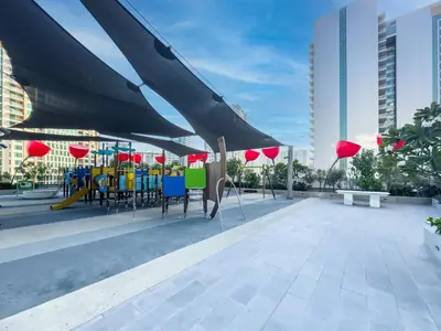 a roof deck with tables and chairs and red umbrellas at Spacious Studio with Balcony I Near Dubai Mall & Downtown in Dubai
