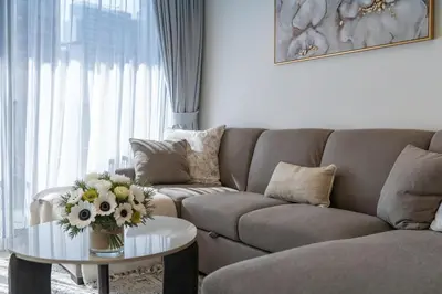 a living room with a couch and a table with flowers on it at Chic Downtown Act Tower Walk to Burj Khalifa&Mall in Dubai