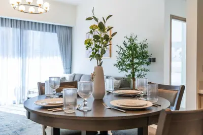 a dining room table with plates and glasses on it at Chic Downtown Act Tower Walk to Burj Khalifa&Mall in Dubai