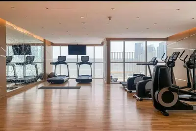 a gym with treadmills and exercise equipment in a building at Modern Luxury Studio Damac Hills With Golf View in Dubai