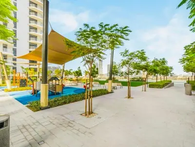 a park with a playground and trees and a building at Exquisite Beachfront 1BR l Palace Beach Residence in Dubai