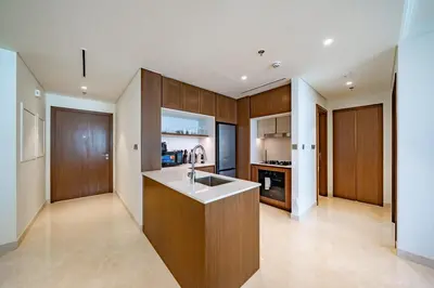 a kitchen with wooden cabinets and a counter top at Exquisite Beachfront 1BR l Palace Beach Residence in Dubai