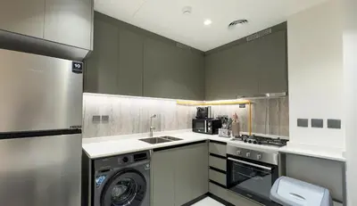 a kitchen with a washer and dryer in it at Werova - Modern 1BR Apartment Prime JVT Location in Dubai