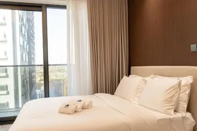 a hotel room with a bed with towels on it at Werova - Modern 1BR Apartment Prime JVT Location in Dubai