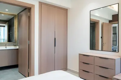 a bathroom with a mirror and a dresser with a sink at Werova - Modern 1BR Apartment Prime JVT Location in Dubai