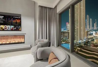 a living room with two chairs and a fireplace at Exclusive Apartments in Burj Vista Downtown Dubai Near Burj Khalifa in Dubai