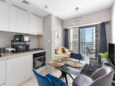 a kitchen and living room with a table and chairs at Luxurious 1 BDR Zada Tower Business Bay 12 in Dubai