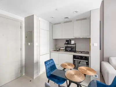 a kitchen with a table and blue chairs in a room at Luxurious 1 BDR Zada Tower Business Bay 12 in Dubai
