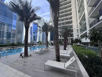 a courtyard with palm trees and a pool in a building at Luxurious 1 BDR Zada Tower Business Bay 12 in Dubai