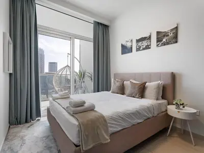 a bedroom with a bed and a large window at Reva Residence Comfort Suite 1BDR Plus Sofa Bed in Dubai