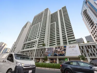 two cars parked in front of a large building at Reva Residence Comfort Suite 1BDR Plus Sofa Bed in Dubai