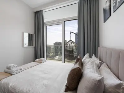 a bedroom with a bed with a large window at Reva Residence Comfort Suite 1BDR Plus Sofa Bed in Dubai