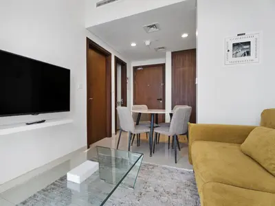 a living room with a couch and a table at Reva Residence Comfort Suite 1BDR Plus Sofa Bed in Dubai