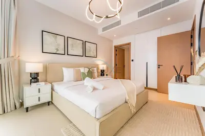 a bedroom with a large white bed and a chandelier at Prime Location with Direct Mall and Marina Walk Access, Just Outside DMCC Metro Station - VIDA Residences, Dubai Marina by Deluxe Holiday Homes in Dubai