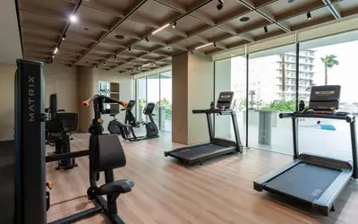 a gym with several treadmills and elliptical machines at Platinum 1BR W Private Pool Binghatti Royale in Dubai