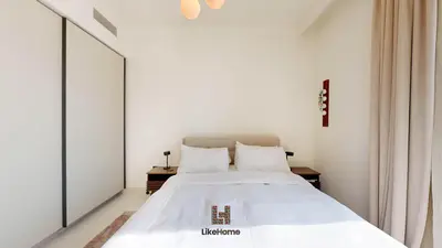 a bedroom with a large white bed with two tables at Stunning 2BR Beachfront Living Marina Vista Tower 2 in Dubai