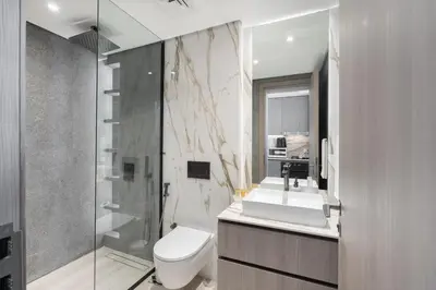 a bathroom with a toilet and a sink and a shower at Chic Pool-View Studio Oxford Gardens by Czechin in Dubai
