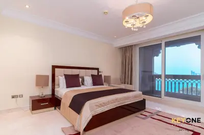 a bedroom with a bed and a large window at Spacious Beachfront 2BR with Maids Room in Grandeur in Dubai