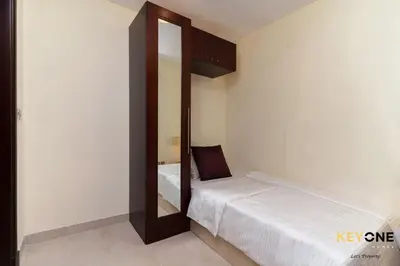 a small bedroom with a bed and a mirror at Spacious Beachfront 2BR with Maids Room in Grandeur in Dubai